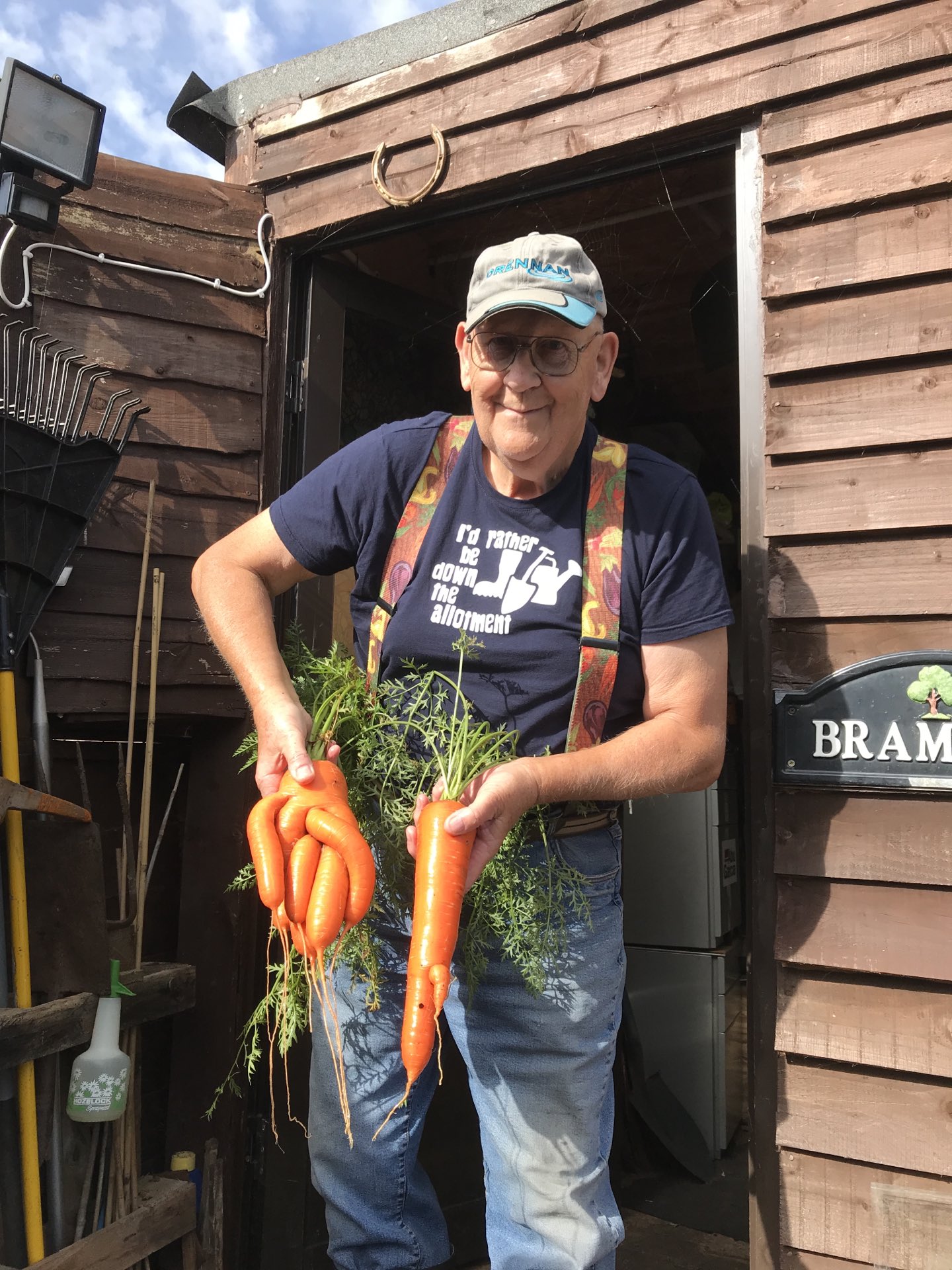 Gerald Stratford holds two carrots, one of which is multi-fingered.