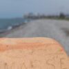 Stone with the word 'MARSE' on it against the backdrop of Batumi.