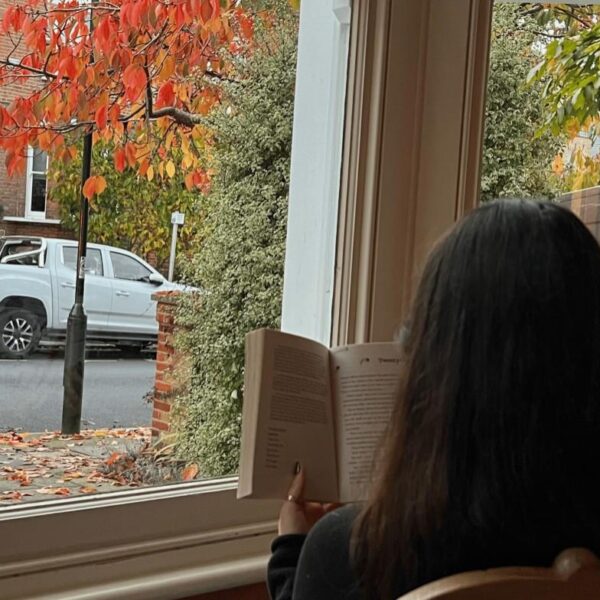 Girl reading a book in front of a window