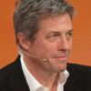 Hugh Grant against orange backdrop