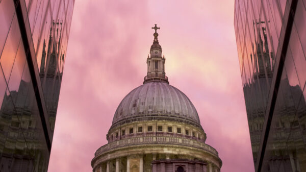 View of St Paul's ain the middle of skyscrapers at sunset.