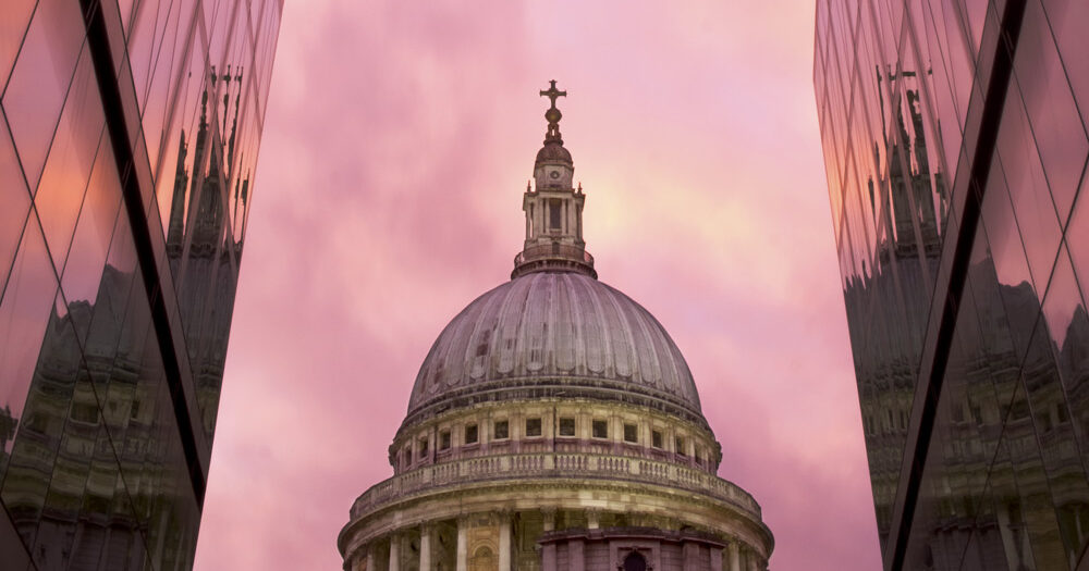 View of St Paul's ain the middle of skyscrapers at sunset.