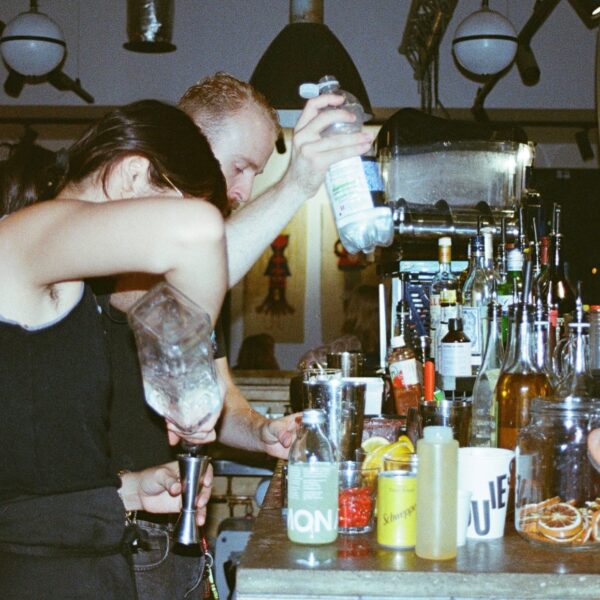 Baretenders pour drinks behind a bar