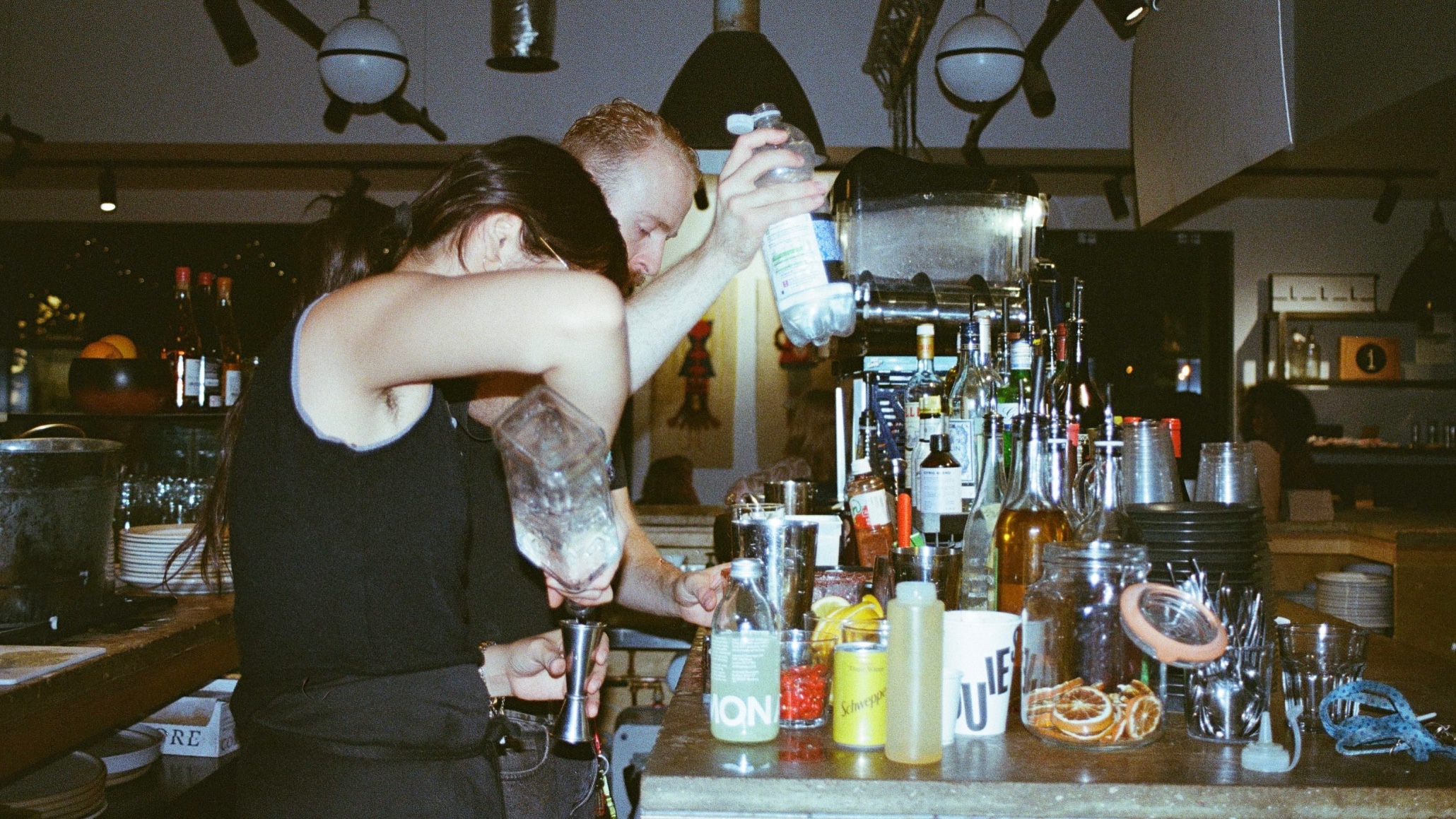 Baretenders pour drinks behind a bar