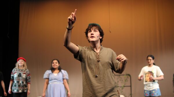 Luis Felipe B. de Mello as Peter Pan gestures in the foreground, Anushka Subhanam as Wendy and assorted Lost Boys fill out the background.